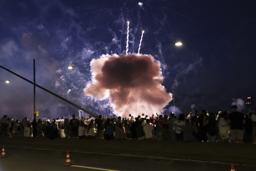 祭り会場の観衆の近くで爆発する花火=18日、デュッセルドルフ(DPA提供・AP=共同)