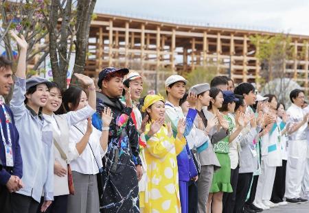 　４月、大阪・関西万博が開幕し来場者を迎えるスタッフら＝大阪市此花区の夢洲