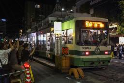 　営業を終了する「猿猴橋町」電停に到着した広島電鉄の路面電車＝２日深夜、広島市南区