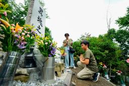 　日航機墜落事故現場の尾根に立つ「昇魂之碑」で手を合わせる遺族＝１２日午前、群馬県上野村
