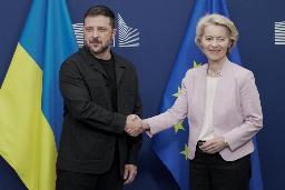 17日、ブリュッセルで握手するEUのフォンデアライエン欧州委員長(右)とウクライナのゼレンスキー大統領(ロイター=共同)