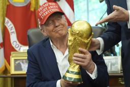 　サッカーＷ杯組み合わせ抽選の日程発表で、優勝トロフィーを手にするトランプ大統領＝２２日、ワシントン（ＡＰ＝共同）