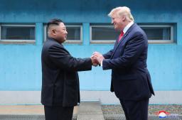 板門店で対面し、握手する北朝鮮の金正恩朝鮮労働党委員長(左)とトランプ米大統領=2019年6月30日(朝鮮中央通信=共同)