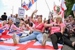 英南東部ハートフォードシャーのホテル前で、難民申請者の立ち退きを求めるデモの参加者=22日(共同)