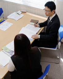 　長野県公安委員会の裁定について弁護士（奥）と相談する男児の母親＝４月、長野県飯田市