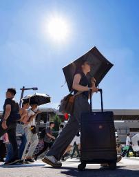 名古屋市で日傘を差して歩く人たち。最高気温40度を観測した=31日午後