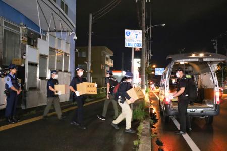 　アレフの施設から押収物を運び出す北海道警の捜査員＝１日午後８時ごろ、札幌市白石区