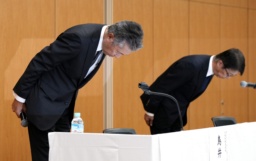 新浪剛史会長の辞任について、記者会見で頭を下げるサントリーHDの鳥井信宏社長(左)と山田賢治副社長=2日午後、東京都港区