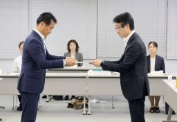 大分労働局長(左)に答申する大分地方最低賃金審議会の井田雅貴会長=4日午後、大分市