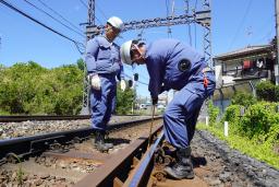 　猛暑の中、レールを点検する近鉄の作業員＝８月、大阪府羽曳野市