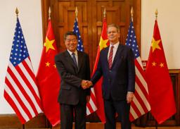 中国の何立峰副首相(左)と米国のベセント財務長官=14日、スペイン・マドリード(米財務省提供・ロイター=共同)