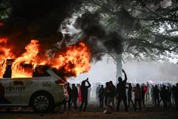 　オランダ西部ハーグで２０日、反移民デモが過激化。警察車両が燃やされた（ゲッティ＝共同）