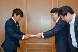 　佐賀県議会議長（左）に要望書を提出する県弁護士会の半田望弁護士（右手前）ら＝１日午前、佐賀市