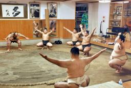 　新師匠の大嶽親方（手前）の下で稽古に臨む王鵬（右端）ら。奥は元横綱大鵬の写真＝東京都江東区の大嶽部屋