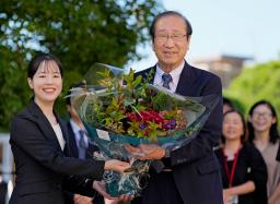 　ノーベル化学賞の受賞決定から一夜明け、職員から花束を受け取る京都大の北川進氏（右）＝９日午前、京都市左京区