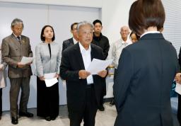 　山口県上関町役場で、担当職員（手前）に申し入れ書を提出する議連幹事長の小中進田布施町議（中央）ら＝２９日午後