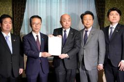 　政治資金規正法の改正案を衆院事務総長（中央）に提出する国民民主と公明両党の議員＝１９日午後、国会　