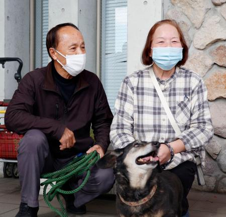 　愛犬のミノと約１日半ぶりに再会した渡辺敏夫さん（左）と妻の寿賀子さん＝２０日午前、大分市佐賀関