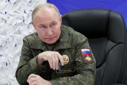 　２０日、ロシア国防省幹部から戦況の報告を受けるプーチン大統領（大統領府提供・タス＝共同）