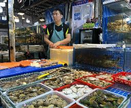　中国北京市にある海鮮市場の鮮魚店で、水産物を販売する従業員＝６月