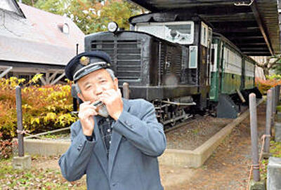猪苗代町の「緑の村」に展示されている沼尻軽便鉄道のディーゼル機関車と客車。ハーモニカで「高原列車は行く」を演奏する鈴木さん