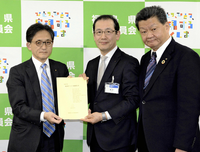 鈴木教育長に実践報告書を手渡す鎌田代表幹事（左）、村越販売局長（右）