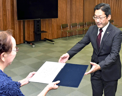 飯間委員長から当選証書を受ける内田氏（右）