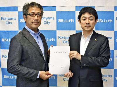 契約書を交わす宮崎社長（左）、椎根市長