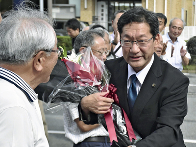 支援者に出迎えられながら初登庁する内田市長（右）