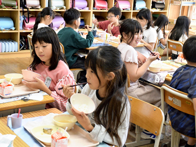 遊水地区域内で収穫されたコメを味わう児童＝鏡石町・鏡石一小