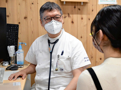 患者を診察する菊池院長。百日ぜきを含め、インフルエンザなどの感染症の同時流行を危惧する