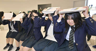 地震・津波を想定して行われた防災訓練。来館した若松商高の生徒らが頭を抱えて１分間動かず身を守った＝５日午前、双葉町・東日本大震災・原子力災害伝承館