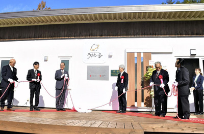 看板を除幕し開所を祝う関係者