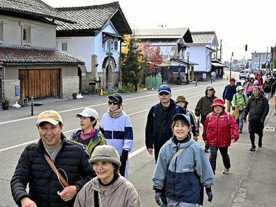 伝統的な蔵が立ち並ぶ「おたづき蔵通り」を歩く参加者＝１５日午前、喜多方市