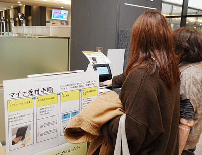 福島赤十字病院内に設置されたマイナンバーカード専用受付で、マイナンバーカードをかざす利用者＝２日午後、福島市