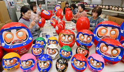 幸せや健康を願い、仕上げ作業が続けられる双葉ダルマ作り＝いわき市泉町の作業場