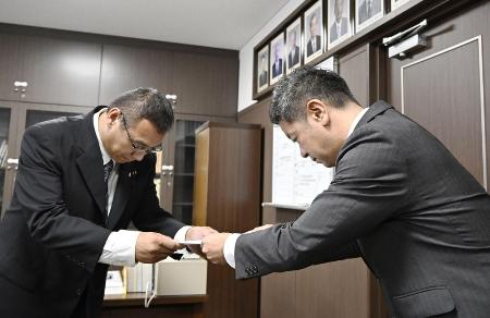 　６月、香川県東かがわ市議会に申し入れを行う上村一郎市長。左は山口大輔副議長＝香川県東かがわ市