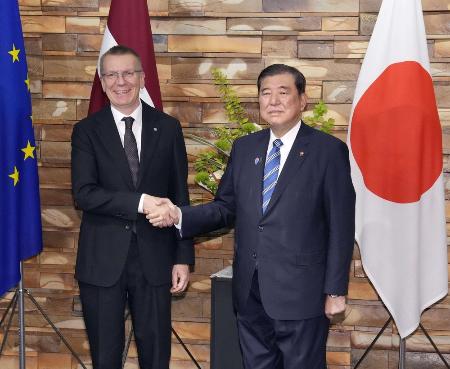　石破首相と握手するラトビアのリンケービッチ大統領（左）５月１９日、首相官邸