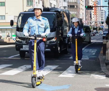 　電動キックボードに乗る警察官＝９日、大阪市中央区