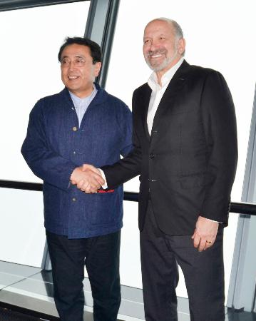 東京スカイツリーの展望台で握手する赤沢経産相(左)とラトニック米商務長官=26日午前、東京都墨田区