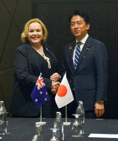 　ニュージーランドのコリンズ国防相（左）と握手する小泉防衛相＝２日、クアラルンプール（共同）